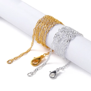 Detailed view of gold and silver water wave chains with lobster clasps for jewelry making