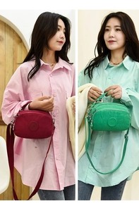 Detailed comparison of red and green nylon crossbody bags with a circular logo patch