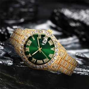 Detail of luxury gold men's watch with iced-out diamonds and green roman numeral dial