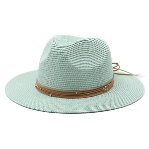 Close-up of light blue Panama straw hat featuring brown leather cord and gold beads