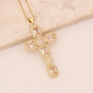 Detailed macro view of 18K gold cross necklace with champagne crystals and cubic zirconia
