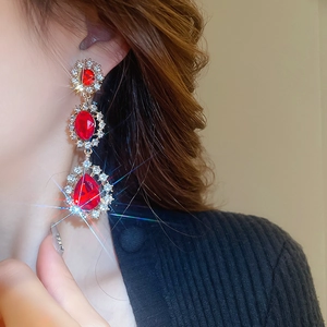 Gros plan de boucles d'oreilles dorées vintage avec pierres rouges et strass étincelants