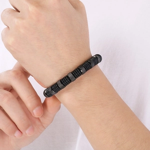 Detailed close-up of men's leather and steel bracelet with knurled metal beads and rubber rings