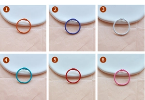 Detail of colorful metal loose-leaf rings in orange, purple, white, cyan, red and pink