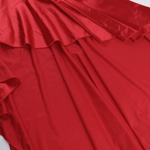 Gros plan sur l'élégant satin rouge foncé avec des volants fluides et brillants