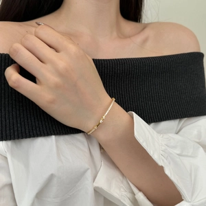 Close-up of golden Mobius S925 silver bracelet with zircon and opal on a model wrist
