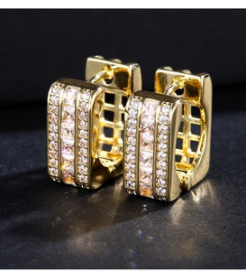 Macro view of gold hoop earrings with rowed square and round white zircon stones