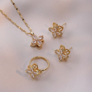Detailed view of rotating flower jewelry set with zircons on champagne satin background
