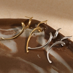 Minimalist stainless steel wavy curve earrings in gold and silver finish on marble tray