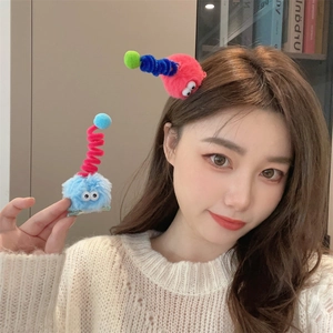 Cute fuzzy plush hair clips with funny eyes and bouncy antennas shown on a model
