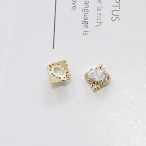 Dettaglio orecchini vintage in oro con zircone bianco ovale e strass scintillanti