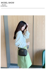 Detailed view of vintage shoulder bag with heart logo and wide patterned strap