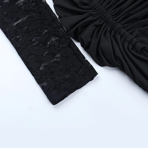 Detailed close-up of delicate black lace sleeve stitching and pleated fabric texture