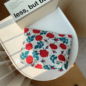 Close-up of vintage red rose floral fabric makeup bag with a secure zipper closure