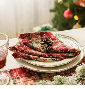 Close-up of red plaid Christmas table runner with white snowflake print and rustic texture