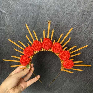 Detailed view of a gold halo headband featuring red roses and a central gold star