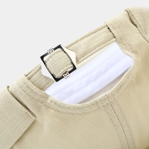 Close-up of adjustable metal buckle and stitching on khaki cotton docker cap