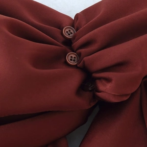 French chic asymmetric midi dress in burgundy featuring round buttons and pleated details