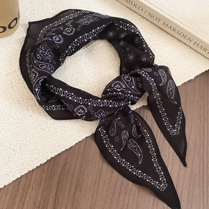 Detail of vintage paisley silk scarf featuring a black and white floral pattern on woven mat