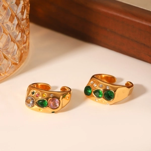 Macro detail of gold hammered rings with green emerald and colorful zircon stones