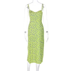Detail view of the back of a green floral midi sundress with delicate purple flower patterns