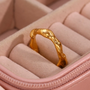 Detail of gold irregular wavy ring displayed in a luxury pink velvet jewelry box