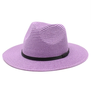 Close-up detail of a purple straw panama hat featuring a fine black ribbon band