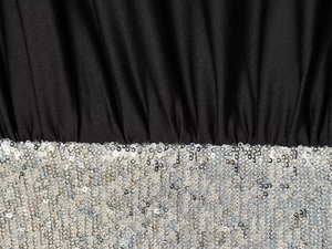 Detailed macro shot of black knit fabric joined with silver sequin embellishments