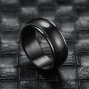 Macro detail of black stainless steel spinner ring with polished surface and brushed interior