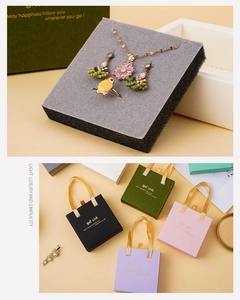 Detail of drawer-style jewelry boxes and matching gift bags in multiple pastel colors
