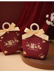 Detail of burgundy wedding favor box with wooden handle and gold foil floral printing