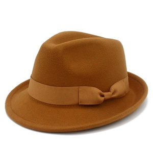 Macro detail of brown wool fedora hat featuring a matching satin ribbon bow band
