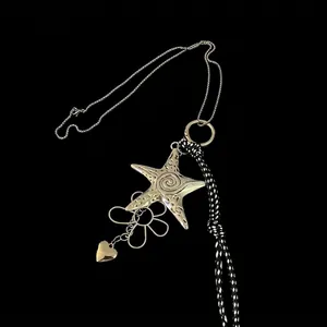 Détails des pendentifs étoile de mer, fleur et cœur sur un collier en cordon