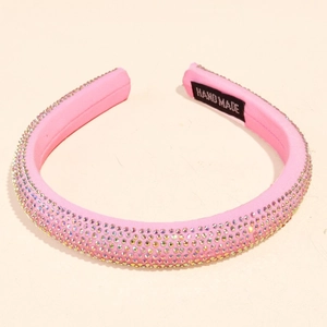 Detail of pink fabric headband featuring colorful rhinestones and handmade inner label