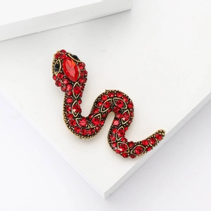 Retro gold snake brooch with red rhinestones on minimalist geometric white podiums