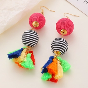 Macro detail of Bohemian tassel earrings with colorful beads and handmade fiber layers