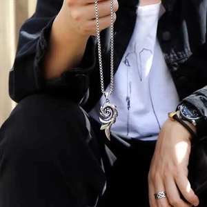 Hip hop style silver flame spiral pendant necklace worn by model on black jacket
