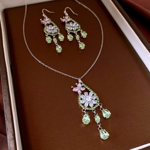 Détail d'une parure collier et boucles d'oreilles fleurs en argent et zircons sur de la soie