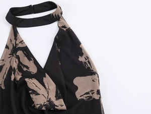 Detail of mesh halter neck dress featuring black and beige floral prints on thin fabric