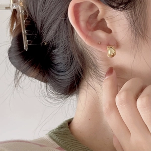 Close-up of gold beaded edge hoop earring showing vintage textured metal craftsmanship