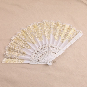 Detailed view of white plastic folding fan with gold lace patterns and golden powder