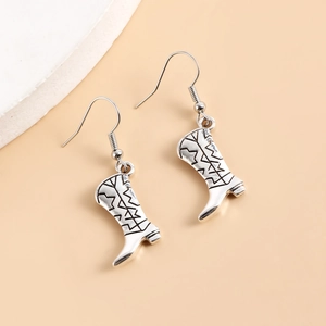 Gros plan détaillé de boucles d'oreilles bottes de cowboy vintage en argent à crochets