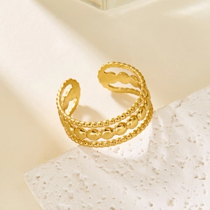 Detail of gold multilayer beaded ring on white stone texture, adjustable geometric design