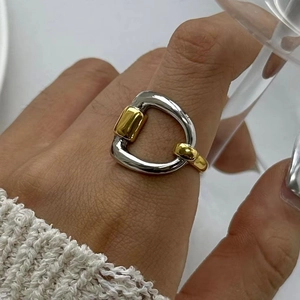 Close-up of a two-tone stirrup-shaped stainless steel ring in gold and silver finish