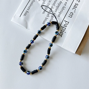 Handmade beaded phone strap with black discs, gold beads, and blue evil eye charms