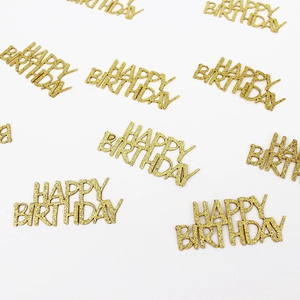 Close-up of sparkling gold glitter Happy Birthday confetti on a plain white background
