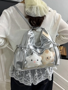 Silver metallic ita bag with clear PVC window and plush stars shown on model's back