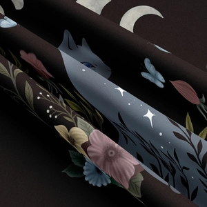 Detailed view of black cat tapestry fabric showing floral patterns and mystical stars