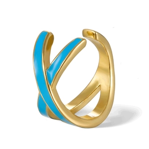 Detail of cross-shaped gold ear cuff with vibrant blue enamel inlay and polished finish