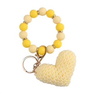 Detail of yellow beaded wristlet keychain with a hand-knitted crochet heart pendant